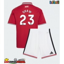 Camisa de Futebol Manchester United Luke Shaw #23 Equipamento Principal Infantil 2026-27 Manga Curta (+ Calças curtas)